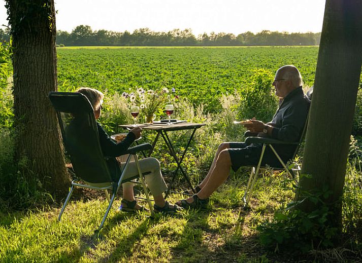 Cozy indoor area of Huisje in Papenvoort, vacation home in Central Drenthe, with wooden interior and cozy sitting area.