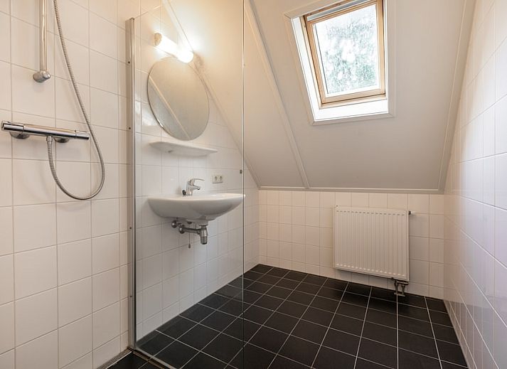 Gemuetliches Wohnzimmer der Zandduin Villa mit Sauna 10 in Hooghalen, Zentral-Drenthe, mit bequemen Sitzgelegenheiten und Blick auf die Natur.