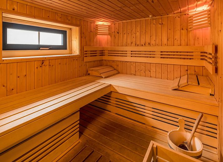 Gemuetliches Wohnzimmer der Zandduin Villa mit Sauna 10 in Hooghalen, Zentral-Drenthe. Gemuetliche Sitzecke und moderne Kueche fuer einen entspannten Aufenthalt.