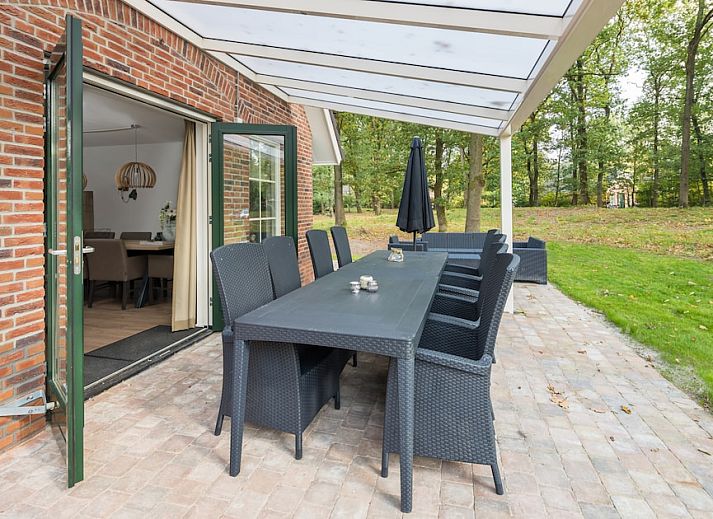 Gemuetliches Wohnzimmer im Vennenhof Wellness Bungalow 6, Hooghalen, Drenthe mit moderner Einrichtung und Blick auf die gruene Umgebung.