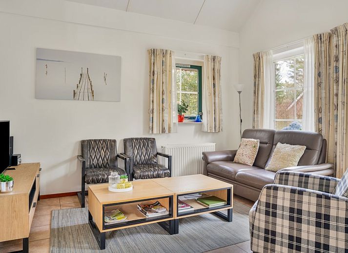 Gemuetliches Wohnzimmer von Esdorp Bungalow 4 in Hooghalen, Drenthe, mit bequemer Sitzecke und natuerlichem Licht.