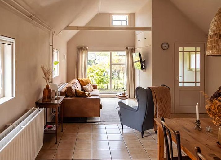 Lichte woonkamer in Vakantiehuisje in Hooghalen met comfortabele zitbank, ideaal voor ontspanning in Midden Drenthe, Drenthe.