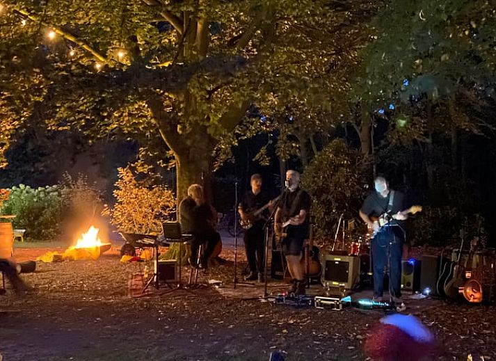 Geniet van de zonsondergang bij Huisje in Mantinge, Midden Drenthe, met comfortabele stoelen en uitzicht over velden.