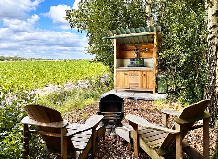Charmanter Wohnwagen im Ferienhaus in Mantinge, Zentral-Drenthe, umgeben von viel Gruen fuer ein rustikales Erlebnis.