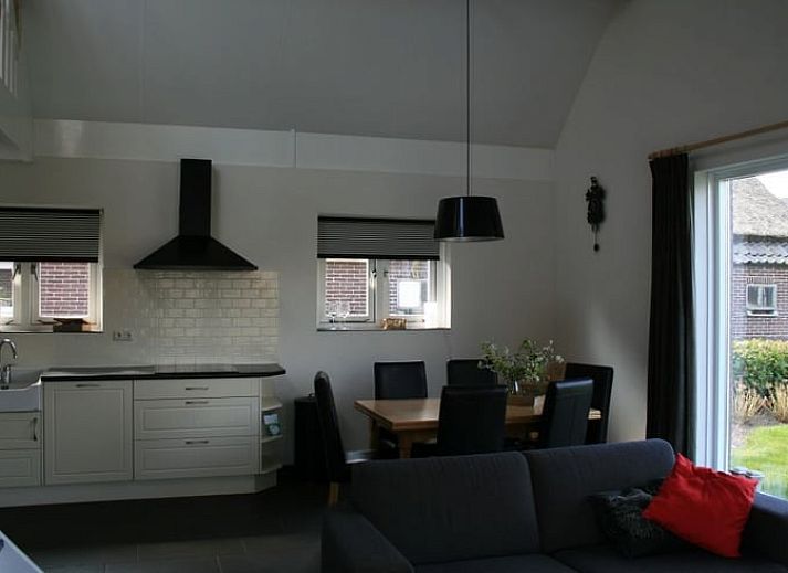 Zonnige tuin van Huisje in Eesergroen, vakantiehuis in Midden Drenthe met groene omgeving en bloemen.