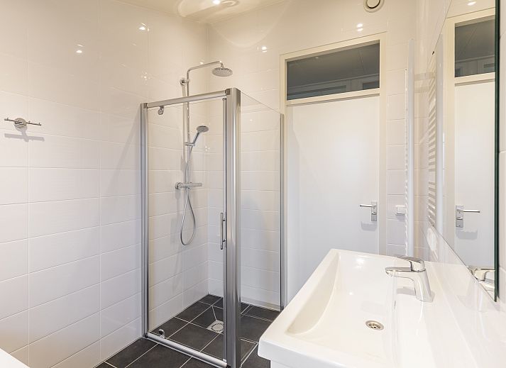 Cozy living room in Hof van Saksen 4-person bungalow 4B in Nooitgedacht, Midden Drenthe with modern kitchen and comfortable seating area.