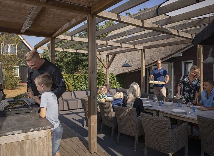 Ruim terras bij Hof van Saksen 12-persoons Culinaire boerderij in Nooitgedacht, Drenthe met comfortabele zitgelegenheid.