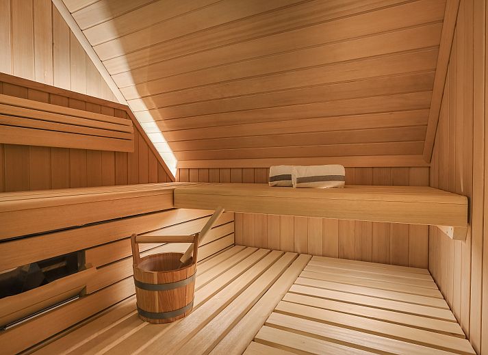 Lichte woonkamer met openslaande deuren in Hof van Saksen 6-persoons Wellnessboerderij, Nooitgedacht, Drenthe.