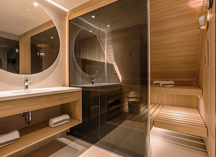 Lichte woonkamer met openslaande deuren in Hof van Saksen 6-persoons Wellnessboerderij, Nooitgedacht, Drenthe.