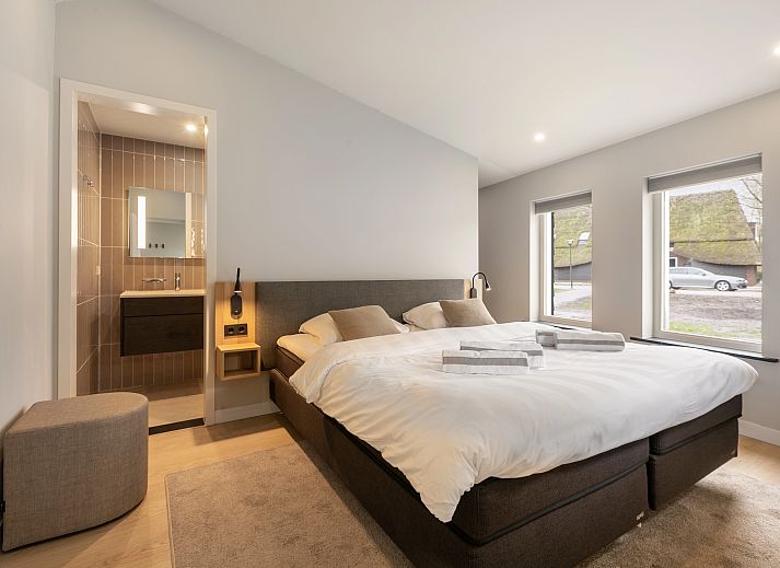 Lichte woonkamer met openslaande deuren in Hof van Saksen 6-persoons Wellnessboerderij, Nooitgedacht, Drenthe.