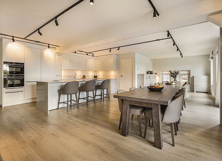 Gezellige woonkamer in Hof van Saksen 18-persoons boerderij, Nooitgedacht, Drenthe met ruime zithoek en open haard.