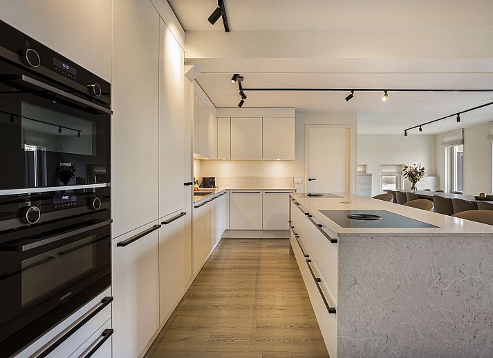 Gezellige woonkamer in Hof van Saksen 18-persoons boerderij, Nooitgedacht, Drenthe met ruime zithoek en open haard.