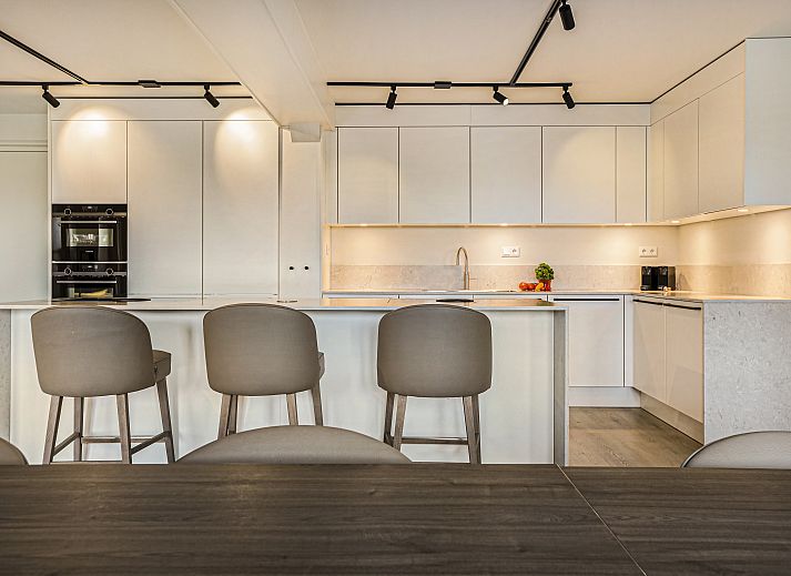 Moderne lounge in Hof van Saksen 18-persoons boerderij, Nooitgedacht, Drenthe met comfortabele banken en sfeerverlichting.