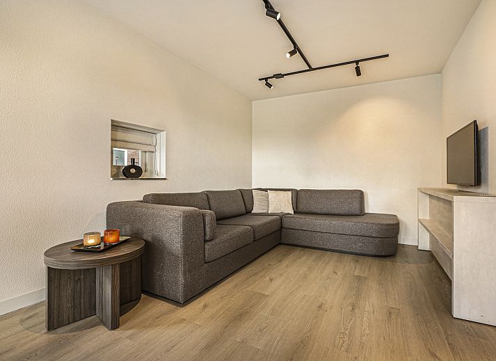 Moderne lounge in Hof van Saksen 18-persoons boerderij, Nooitgedacht, Drenthe met comfortabele banken en sfeerverlichting.