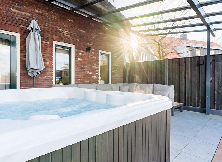 Enjoy luxury in the Jacuzzi at Hof van Saksen, 6-person Wellness Waterfront farmhouse in Nooitgedacht, Drenthe.