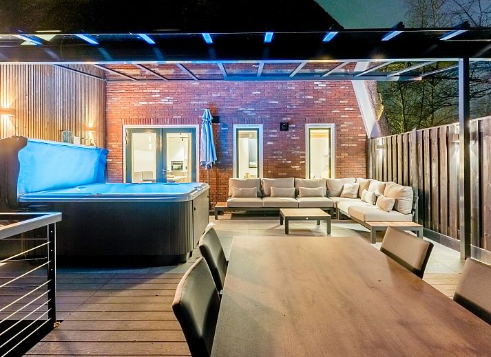 Spacious living room with dining area in Hof van Saksen, 6-bed Wellness Waterfront farmhouse, Nooitgedacht, Drenthe.