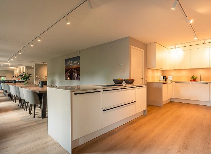 Gezellige zithoek met open haard in de 24-persoons boerderij Hof van Saksen, gelegen in het groene Nooitgedacht, Midden Drenthe.