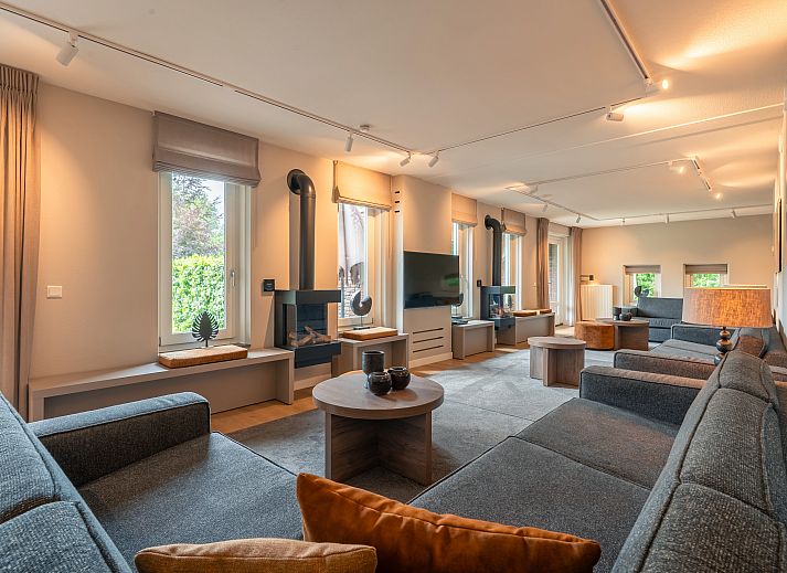 Gezellige zithoek met open haard in de 24-persoons boerderij Hof van Saksen, gelegen in het groene Nooitgedacht, Midden Drenthe.