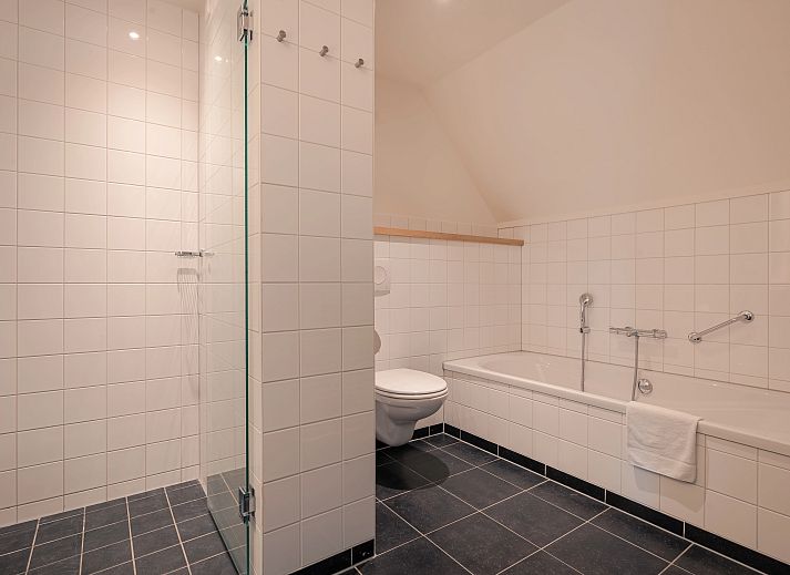 Stijlvolle open leefruimte in Hof van Saksen 24-persoons vakantiehuis in Nooitgedacht, Drenthe, ideaal voor grote groepen.