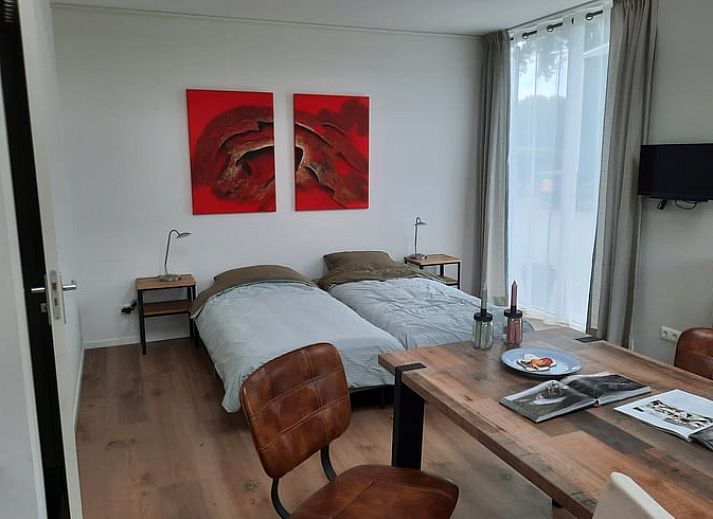 Gemuetliches Schlafzimmer im Ferienhaus in Smilde, Midden Drenthe, mit Kunstwerken und natuerlichem Licht.