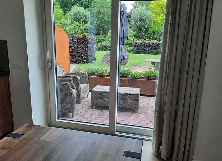 Charmanter Eingang zum Ferienhaus in Smilde, Zentral-Drenthe, mit offenen Fensterlaeden und Blumen.