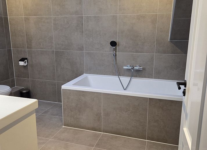 Schoenes Schlafzimmer im Ferienhaus DG2033, Odoorn, Midden Drenthe, mit einem eleganten Bett und sanfter Beleuchtung.