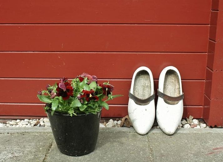 Stilvolles Wohnzimmer im Ferienhaus in Nieuw Balinge, Midden Drenthe, mit bequemen Sitzgelegenheiten und Buecherregalen.