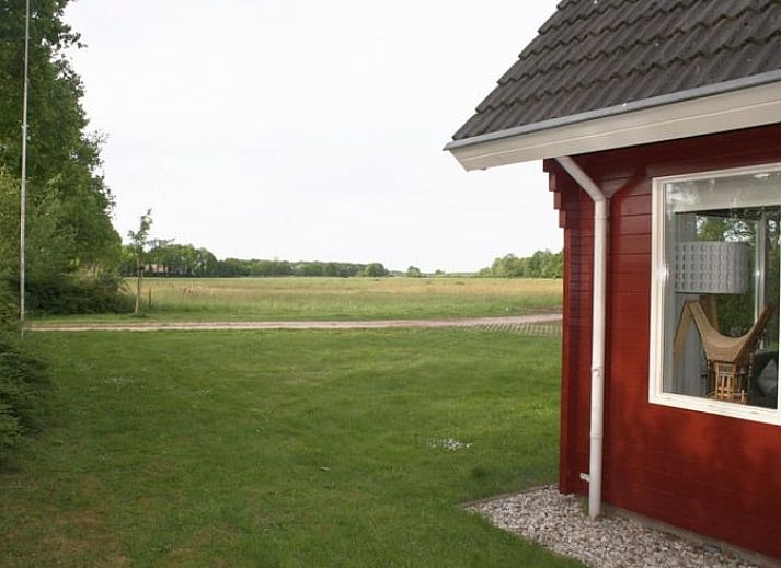 Stilvolles Wohnzimmer im Ferienhaus in Nieuw Balinge, Midden Drenthe, mit bequemen Sitzgelegenheiten und Buecherregalen.