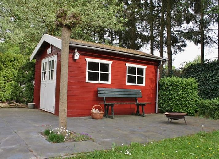 Stilvolles Wohnzimmer im Ferienhaus in Nieuw Balinge, Midden Drenthe, mit bequemen Sitzgelegenheiten und Buecherregalen.