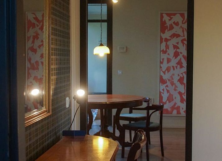 Gemuetlicher Innenbereich des Huisje in Nieuw Balinge, Ferienhaus in Zentral-Drenthe, mit stimmungsvollem Essbereich und warmer Beleuchtung.