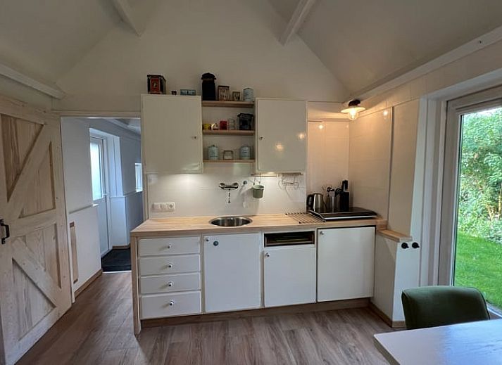 Buitenkant van Huisje in Westdorp, vakantiehuis in Midden Drenthe met charmante bakstenen gevel en groene omgeving.