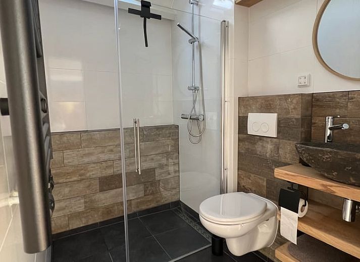 Gezellige woonkamer in Huisje in Westdorp, vakantiehuis in Midden Drenthe met comfortabele zitplaatsen en rustieke inrichting.