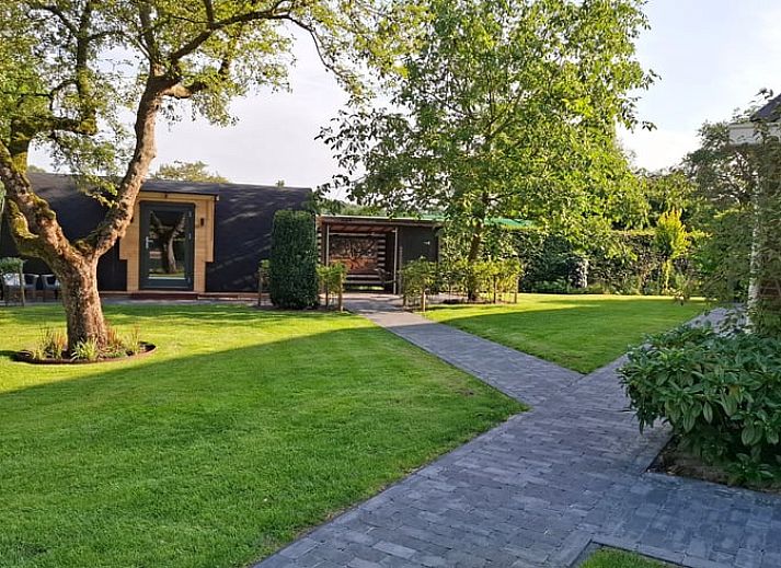 Ferienhaus in Westdorp, Zentral-Drenthe mit charmanter Holzfassade und gruenem Garten.