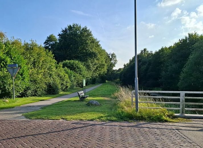 Ferienhaus in Westdorp, Zentral-Drenthe mit gruenem Garten und schattigen Baeumen.