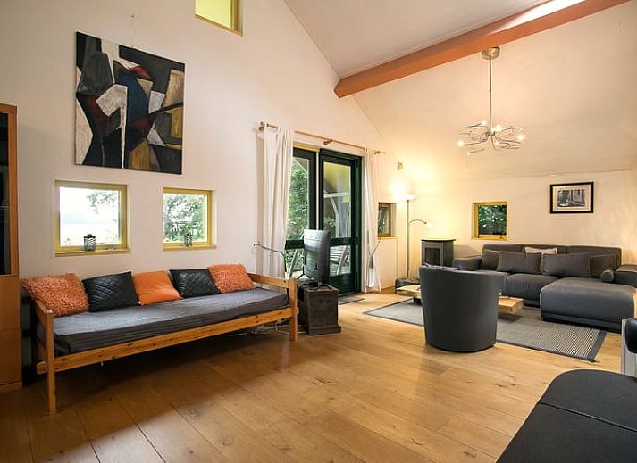 Gezellige eetruimte in Vakantiehuis in Een, Noord Drenthe, met kunst aan de muur en uitzicht op de natuur.