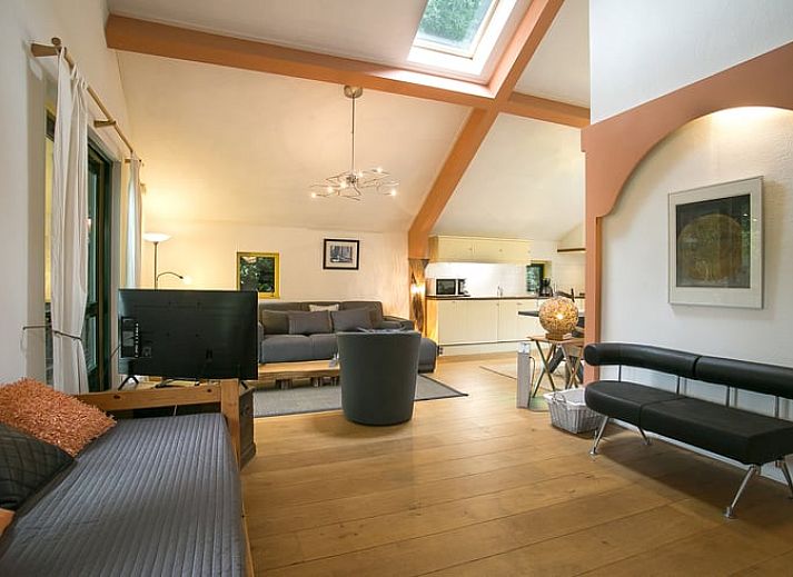 Gezellige eetruimte in Vakantiehuis in Een, Noord Drenthe, met kunst aan de muur en uitzicht op de natuur.