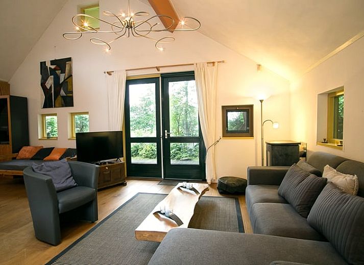 Gezellige eetruimte in Vakantiehuis in Een, Noord Drenthe, met kunst aan de muur en uitzicht op de natuur.