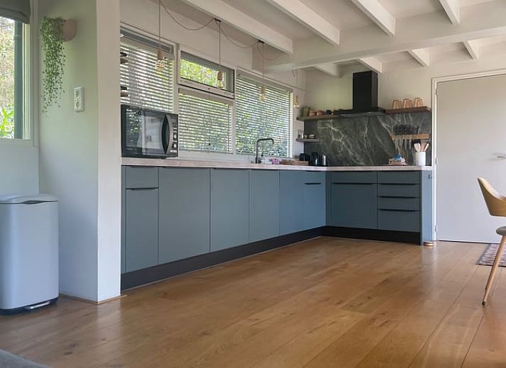 Huisje in Een, Noord Drenthe vakantiehuis met bloeiende heide op de voorgrond.