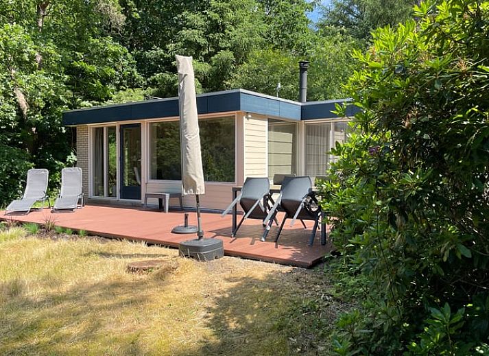 Vakantiehuis Huisje in Een, Drenthe weerspiegeld in een rustige vijver.