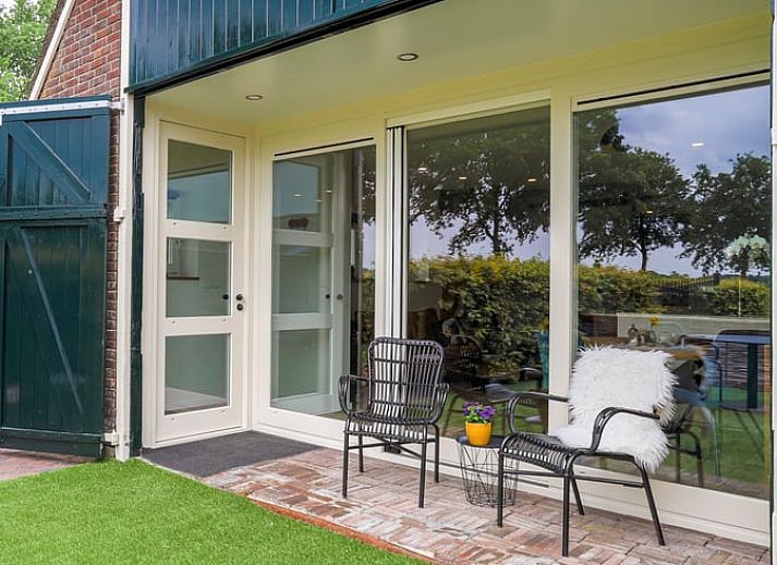 Gemuetliches Wohnzimmer des Ferienhauses in Een, Drenthe, mit modernen Moebeln und bequemen Sitzgelegenheiten.