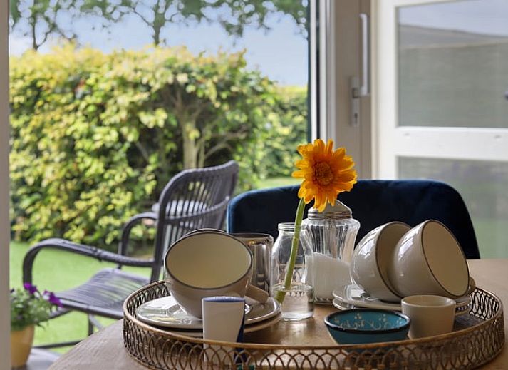 Helles Wohnzimmer im Ferienhaus in Een, Drenthe, mit grossen Fenstern und bequemem Sofa.