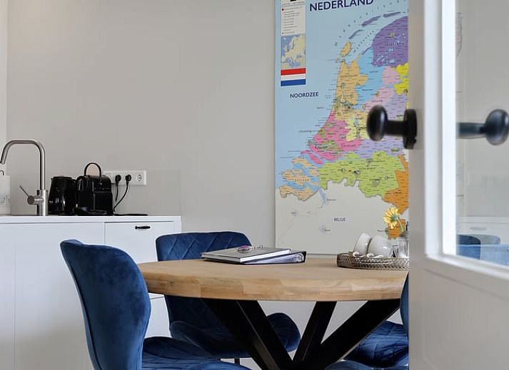 Esszimmer im Ferienhaus in Een, Nord-Drenthe, mit Blick auf den Garten und Kunst an der Wand.