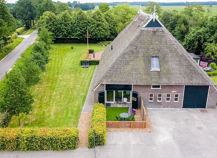 Esszimmer im Ferienhaus in Een, Nord-Drenthe, mit Blick auf den Garten und Kunst an der Wand.