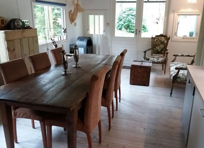 Gemuetliche Terrasse im Cottage in Norg, Ferienunterkunft in Drenthe, umgeben von Baeumen.