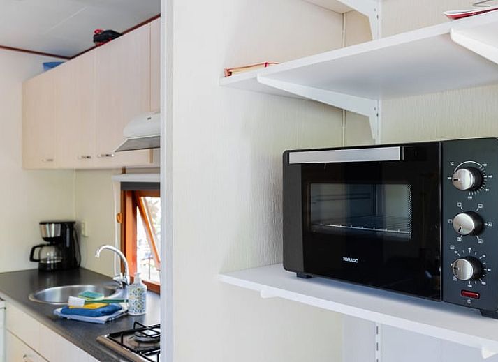 Gezellig terras bij Huisje in Norg, vakantiehuis in Noord Drenthe, met houten tafel en stoelen.