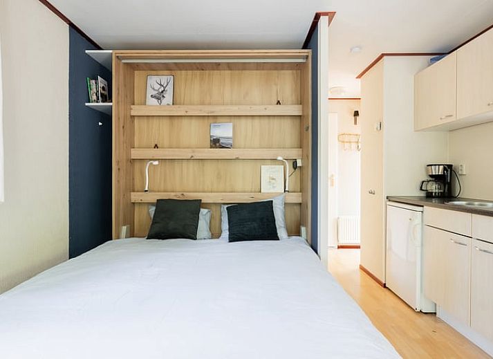 Gezellig terras bij Huisje in Norg, vakantiehuis in Noord Drenthe, met houten tafel en stoelen.