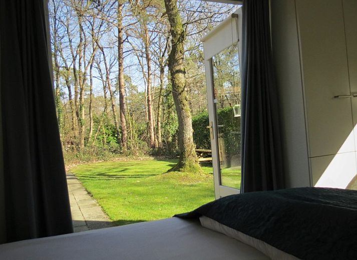Geraeumige Terrasse am Ferienhaus Morgenster in Norg, Drenthe, mit Sitzgelegenheit und gruenem Garten fuer Spass im Freien.
