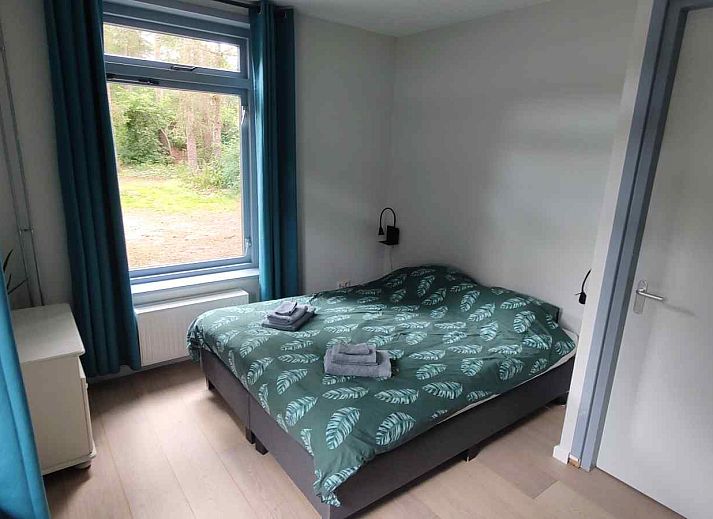 Gemuetliches Schlafzimmer im Ferienhaus DG588 in Midlaren, Drenthe, mit einem Doppelbett und Holzboden.