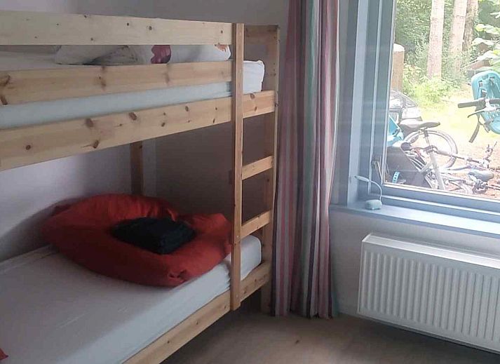 Gemuetliches Schlafzimmer im Ferienhaus DG588 in Midlaren, Drenthe, mit einem Doppelbett und Holzboden.