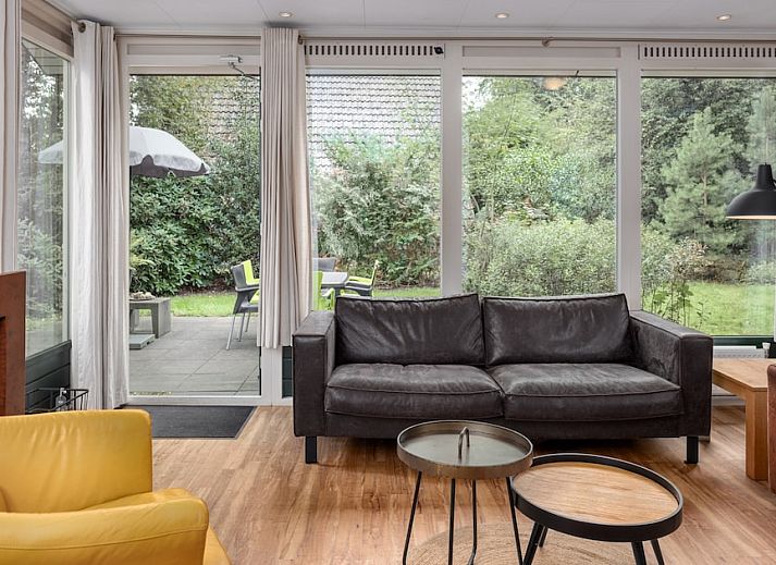 Gemuetliches Wohnzimmer des Bungalows L6A in Borger, Nord-Drenthe mit bequemer Sitzecke und Blick auf die umliegende Landschaft.
